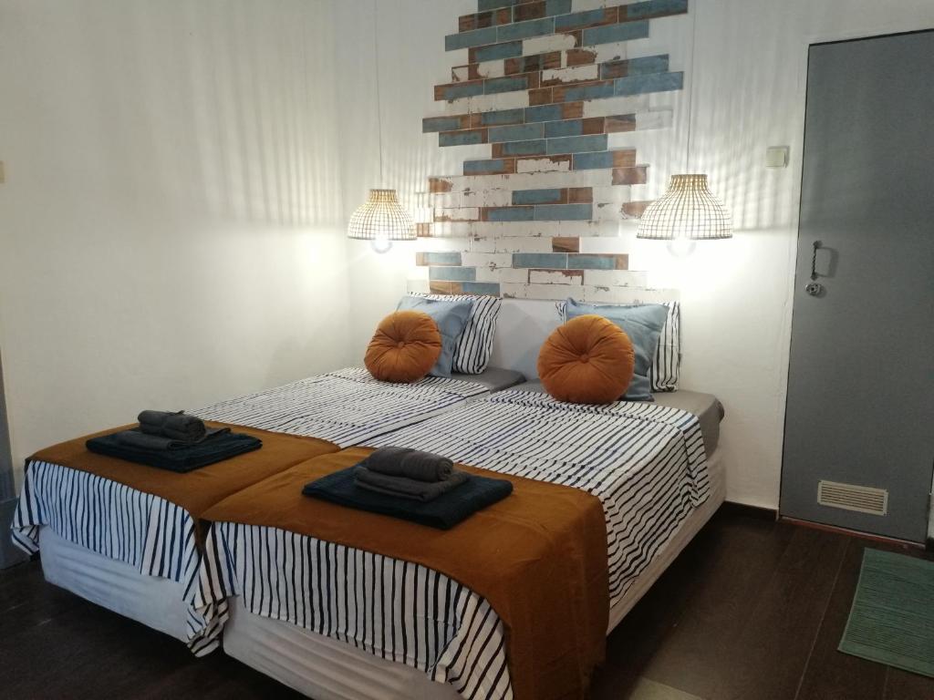 1 dormitorio con 1 cama con almohadas de color naranja en The Portuguese Element en Faro