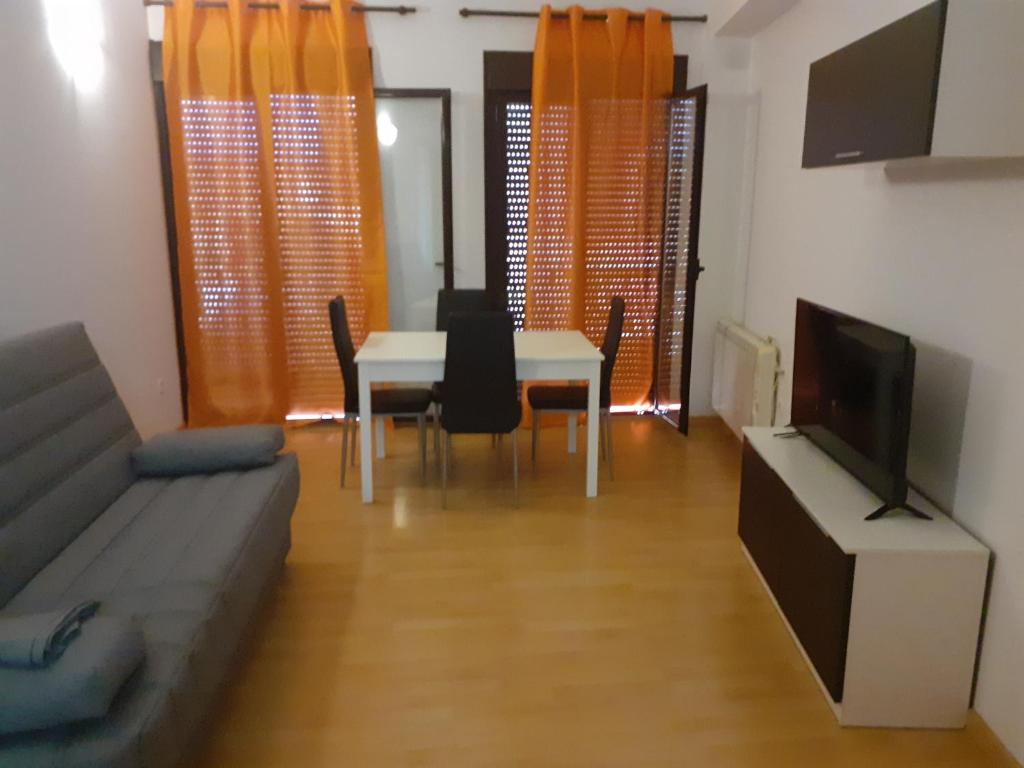 a living room with a table and a couch and a tv at Apartamento casco histórico de Calatayud in Calatayud