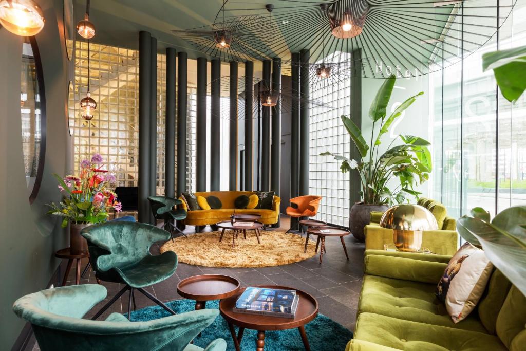 a living room with green furniture and tables and chairs at Hotel2Stay in Amsterdam