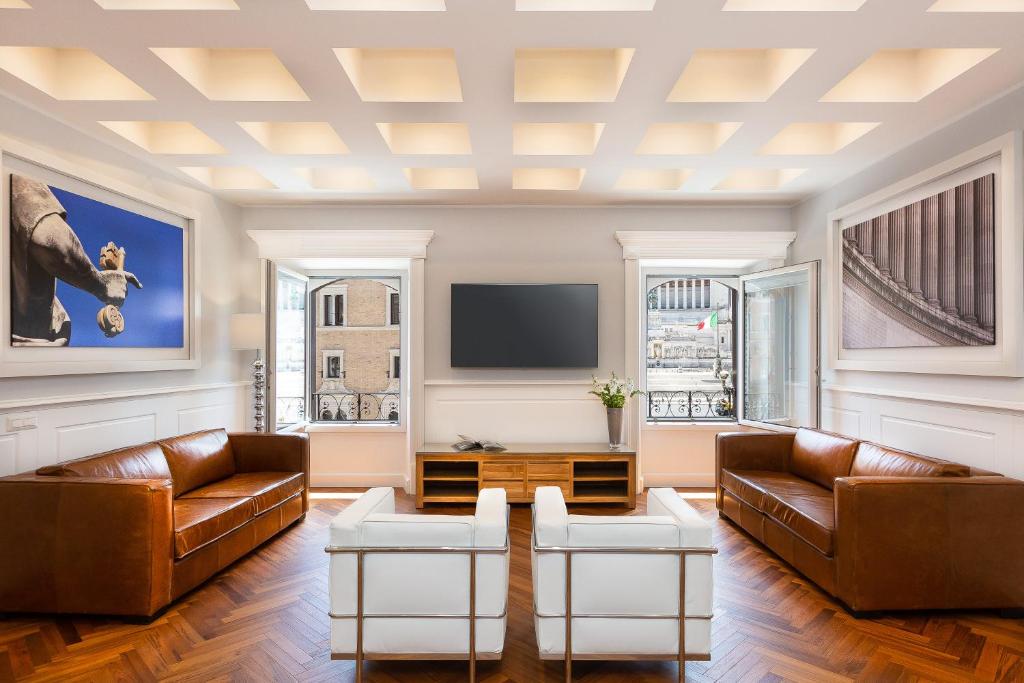 sala de estar con muebles de cuero y TV de pantalla plana en Amazing Vittoriano, en Roma