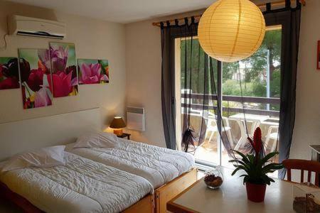 een slaapkamer met een bed, een tafel en een raam bij Hôtel**résidence BEAR in Port-Vendres