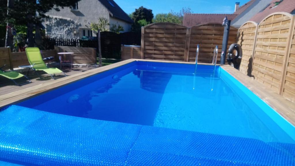 una gran piscina azul en el patio trasero en Gîtelabaronnaise avec piscine chauffée prés parc Asterix, en Baron