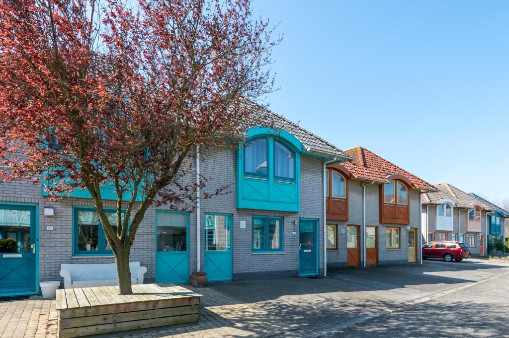 eine Reihe von Häusern mit blauen Fenstern auf einer Straße in der Unterkunft Grasse 148 - Kustpark Village Scaldia in Hoofdplaat