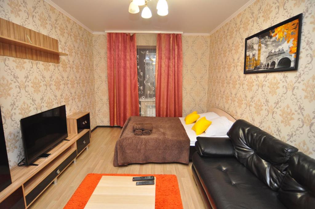 a living room with a couch and a flat screen tv at Apartment on Lva Tolstogo 14G in Kursk