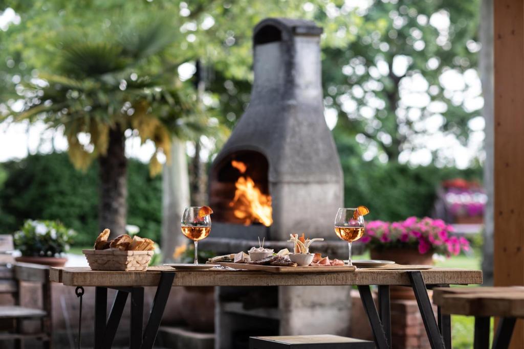 a table with two glasses of wine and a fireplace at Vecchio Granaio in Pisa