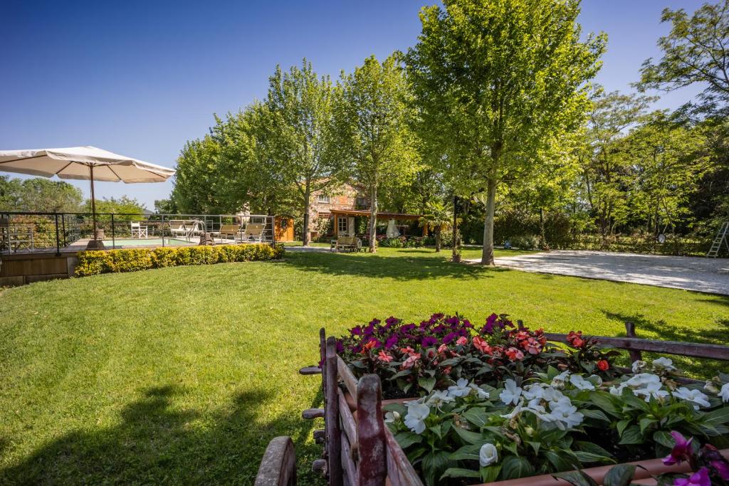a garden with flowers and an umbrella at Vecchio Granaio in Pisa