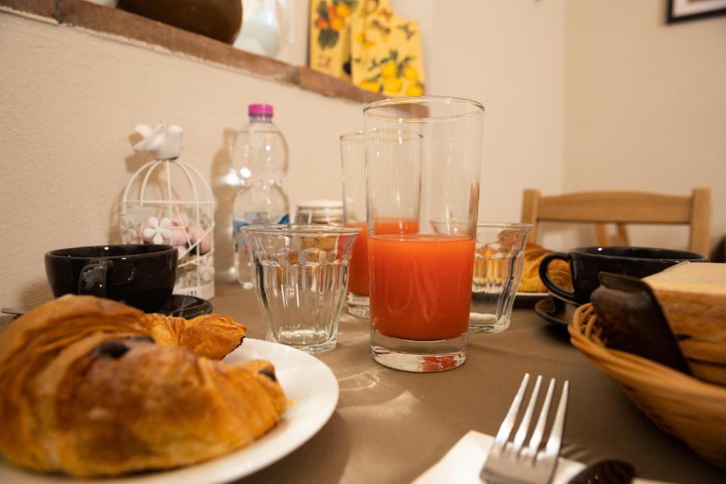a table with a plate of food and a glass of orange juice at Vecchio Granaio in Pisa