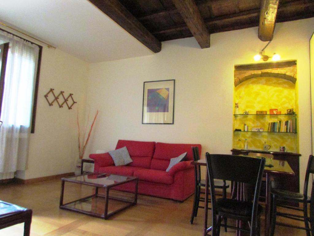 a living room with a red couch and a table at ARIOSTEA Ap.1 in Ferrara
