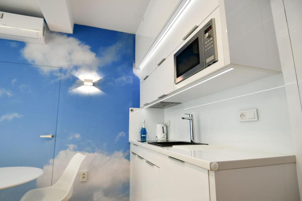 kuchnia ze zlewem i kuchenką mikrofalową w obiekcie Blue Sky Apartments Rezydencja Niechorze w mieście Niechorze