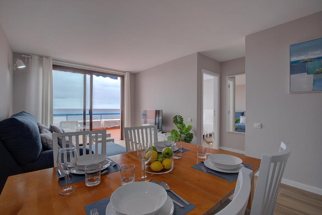 una sala da pranzo con tavolo e sedie e vista sull'oceano di Sonia´s Beach a Los Cancajos