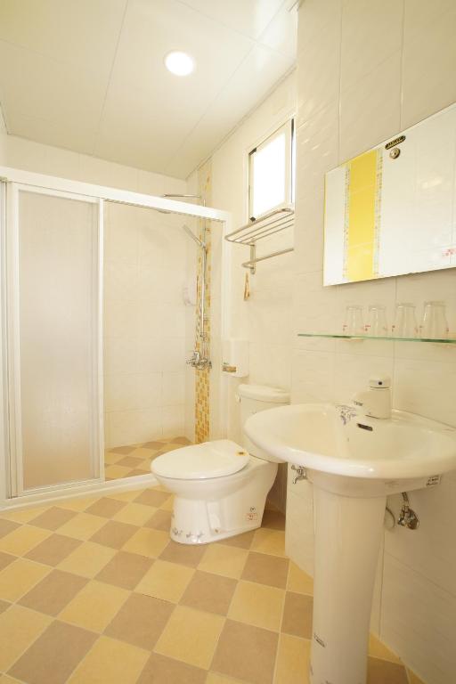 a white bathroom with a toilet and a sink at 貓咪民宿Mini館-中午即可入房 in Taitung City