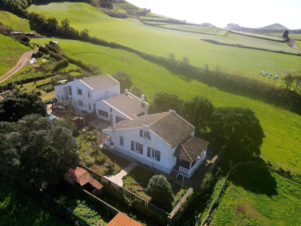 an aerial view of a white house in a green field at Casa da Mediana in Ribeira Grande