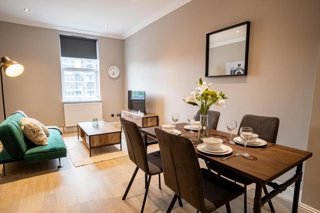 a dining room with a table and a green chair at Deluxe Modern 1&2 Bed Apartments Near Brighton Beach & Station in Brighton & Hove
