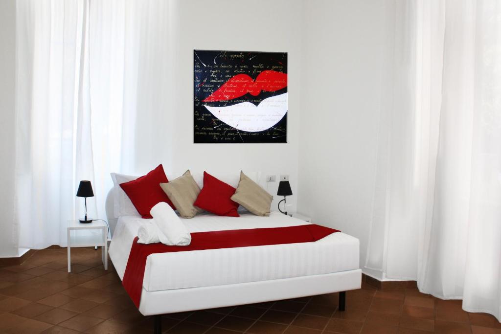 a bedroom with a bed with red and white pillows at Roma Resort Colosseum in Rome