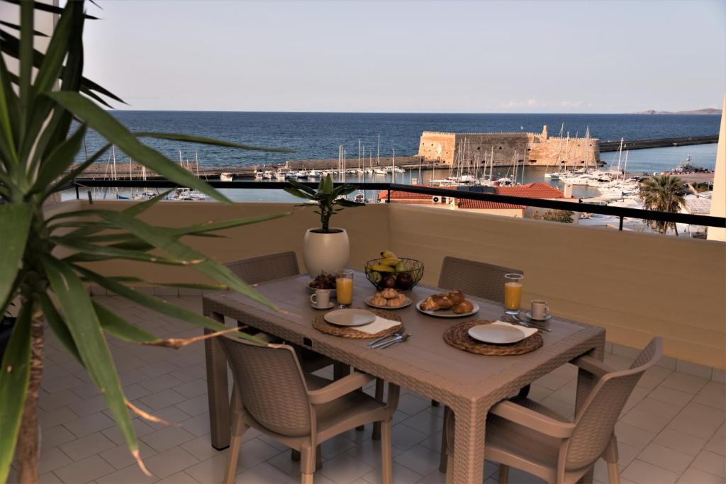 a table on a balcony with a view of the ocean at Koules Sea View City Apartment in Heraklio