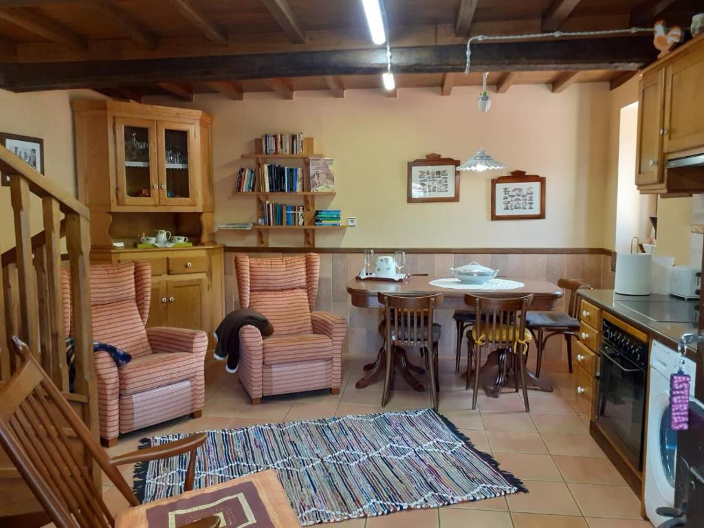 a kitchen with a table and chairs in a room at La casina de santulaya in Cangas del Narcea