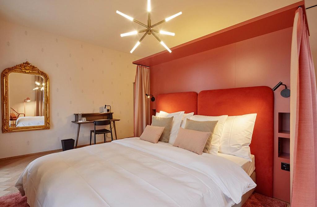 a bedroom with a large white bed with a red headboard at Hotel Restaurant Seehof in Küssnacht