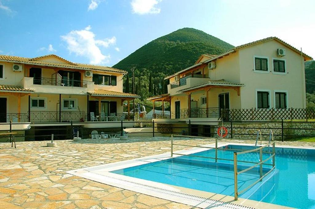 a house with a swimming pool in front of a building at Argovillas in Yenion