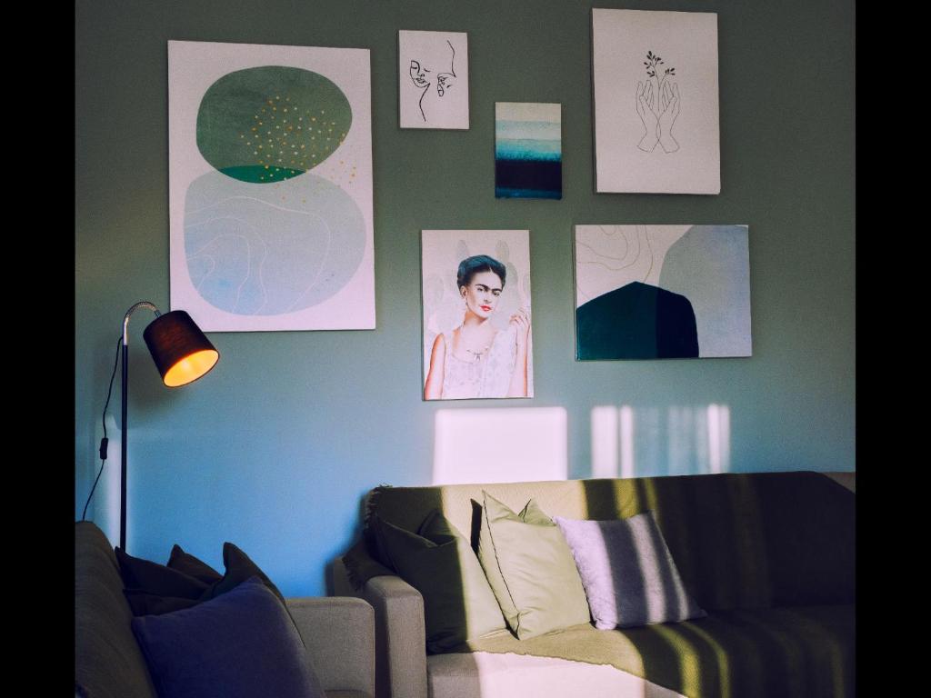 uma sala de estar com um sofá e quadros na parede em Omalia Apartment em Prinos