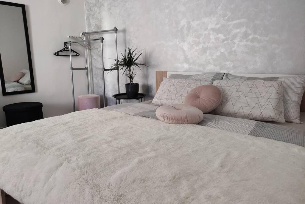 a bedroom with a large white bed with pink pillows at Little Paradise in Pula