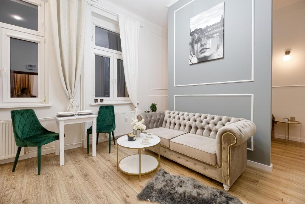 sala de estar con sofá, mesa y sillas en Niron Apartament Dom z Papieru Sztokholm, en Piła