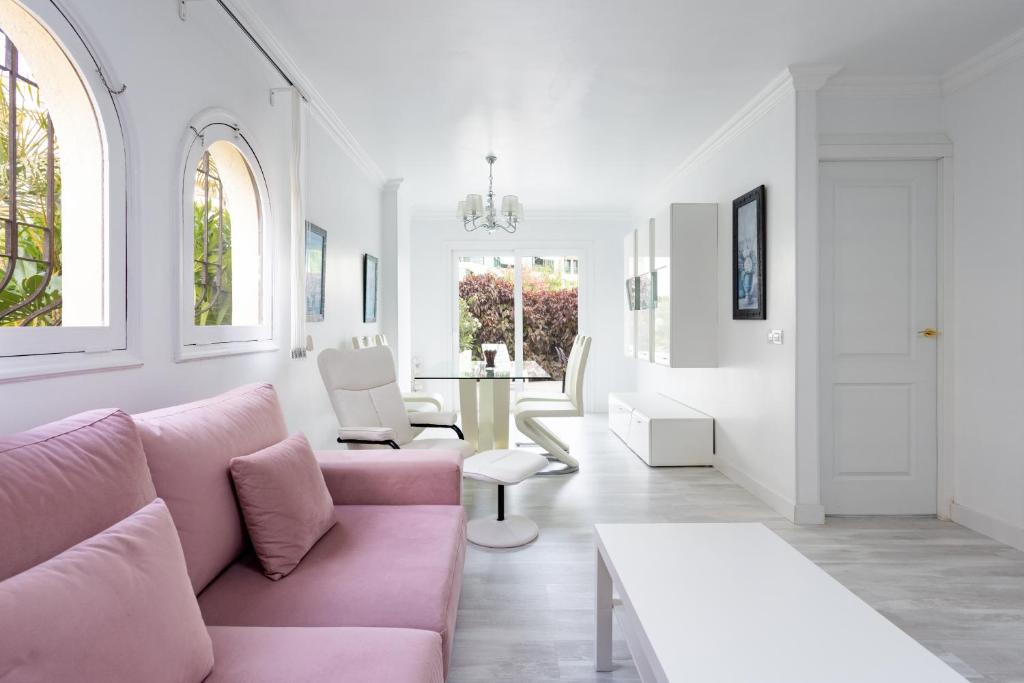 sala de estar con sofá rosa y mesa en Home2Book La Casita del Puerto, terrace & Pool, en Puerto de la Cruz