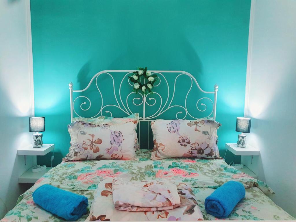 a blue bedroom with a bed with pink pillows at Happy House in Năvodari
