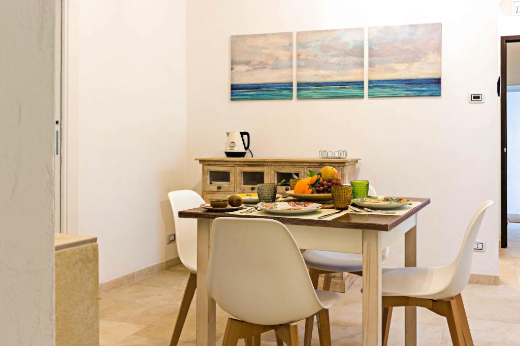 a dining room with a table with chairs and fruit on it at G25 Guesthouse in Monopoli