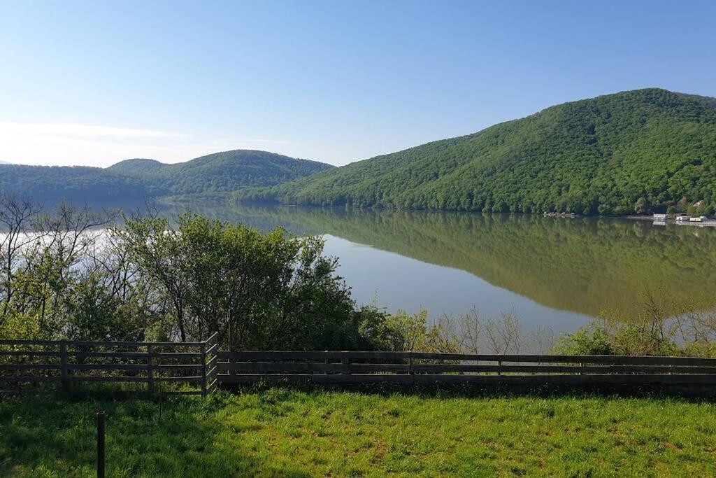 een uitzicht op een meer met een hek ernaast bij Entire Chalet, Amazing Panoramic View of Calinesti Oas Lake in Călineşti-Oaş