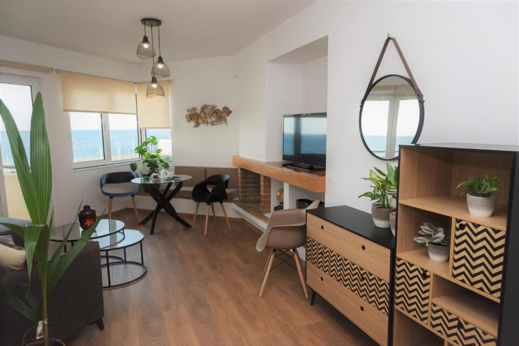 salon z telewizorem i stołem z krzesłami w obiekcie Koules Sea View City Apartment w Heraklionie