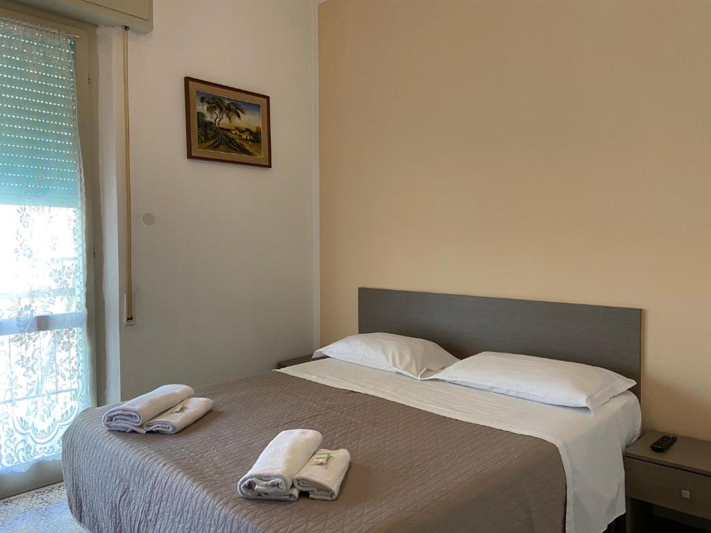 una camera da letto con un letto e due asciugamani di Hotel Britta a Rimini
