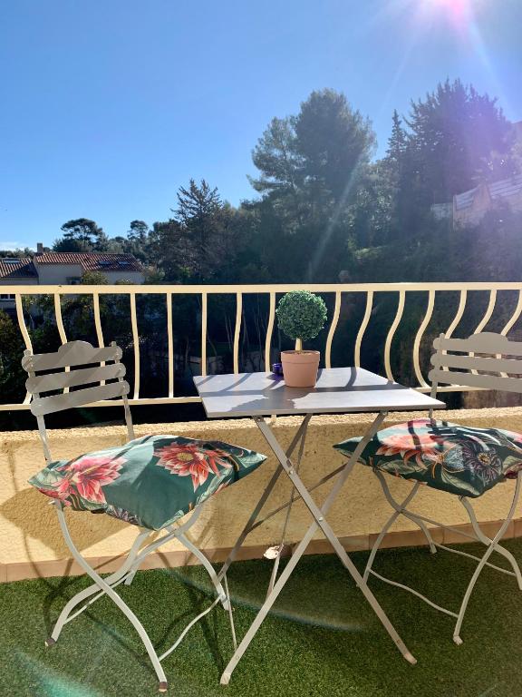 une table et deux chaises sur un balcon dans l'établissement My Little Provence HYERES, à Hyères