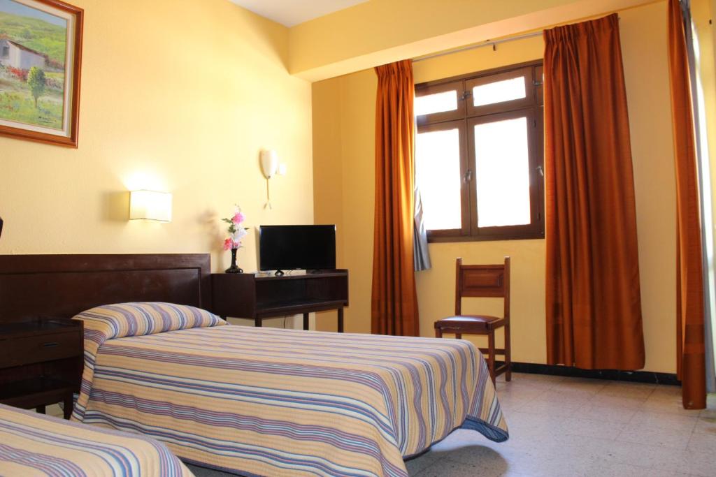 Televízia a/alebo spoločenská miestnosť v ubytovaní Hotel Olympia