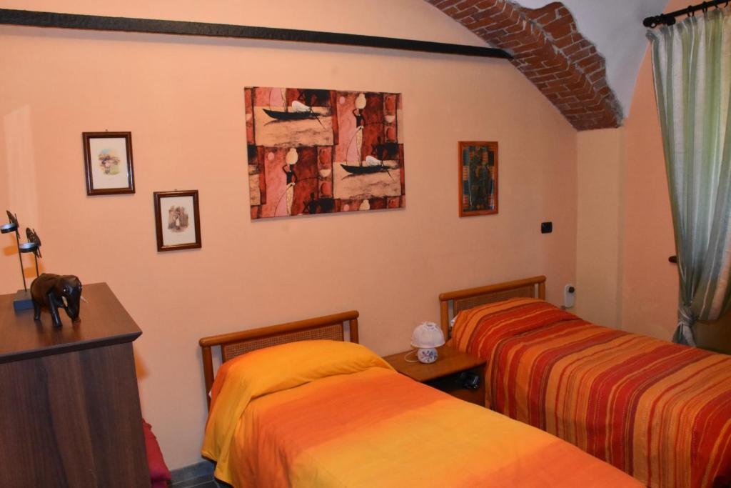 ein Schlafzimmer mit 2 Betten und einem Wandgemälde in der Unterkunft La casa di Enzo in Lequio Tanaro