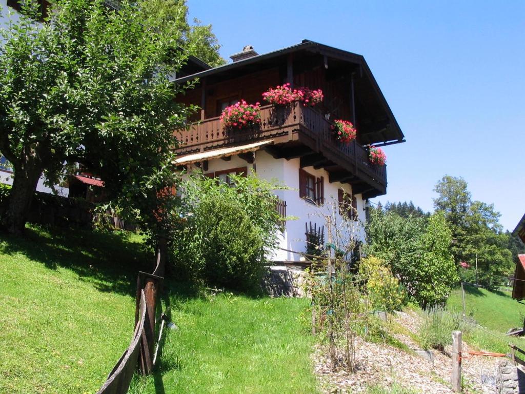 ein Haus mit einem Balkon mit Blumen darauf in der Unterkunft Haus Waidmannsglück in Bischofswiesen