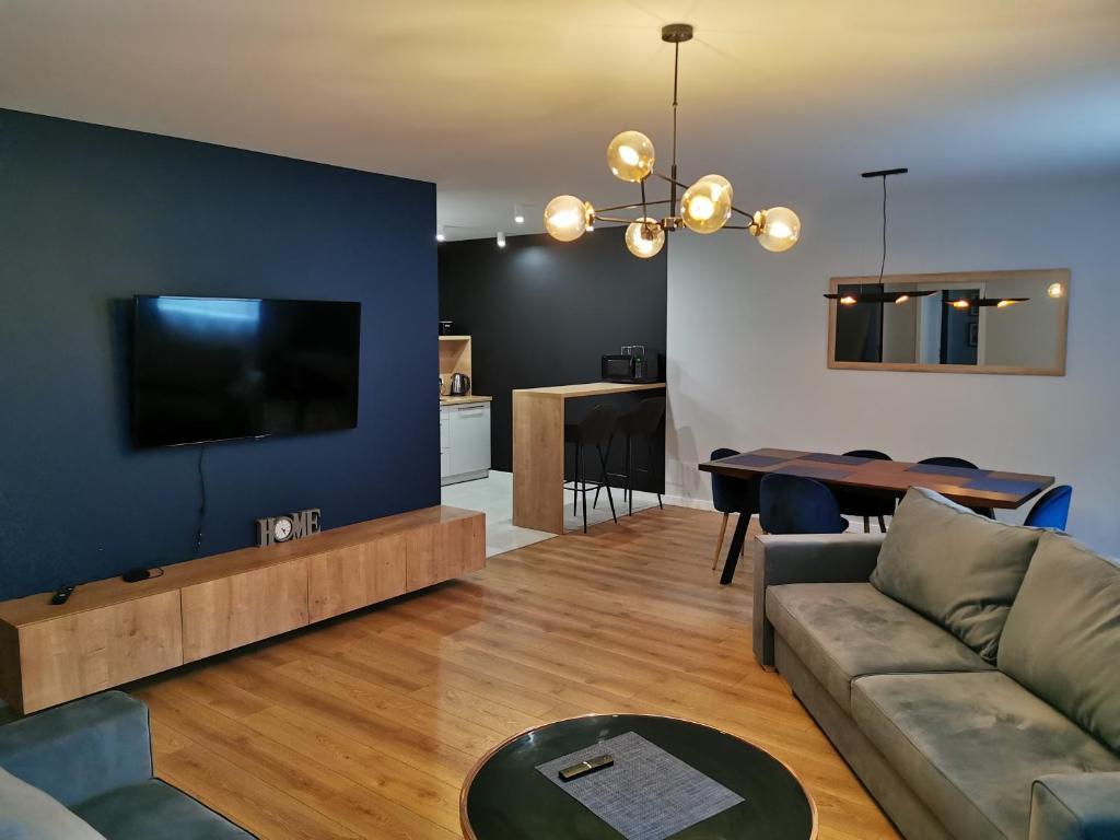 a living room with a couch and a flat screen tv at Leśny Apartament Nad Zalewem in Kielce