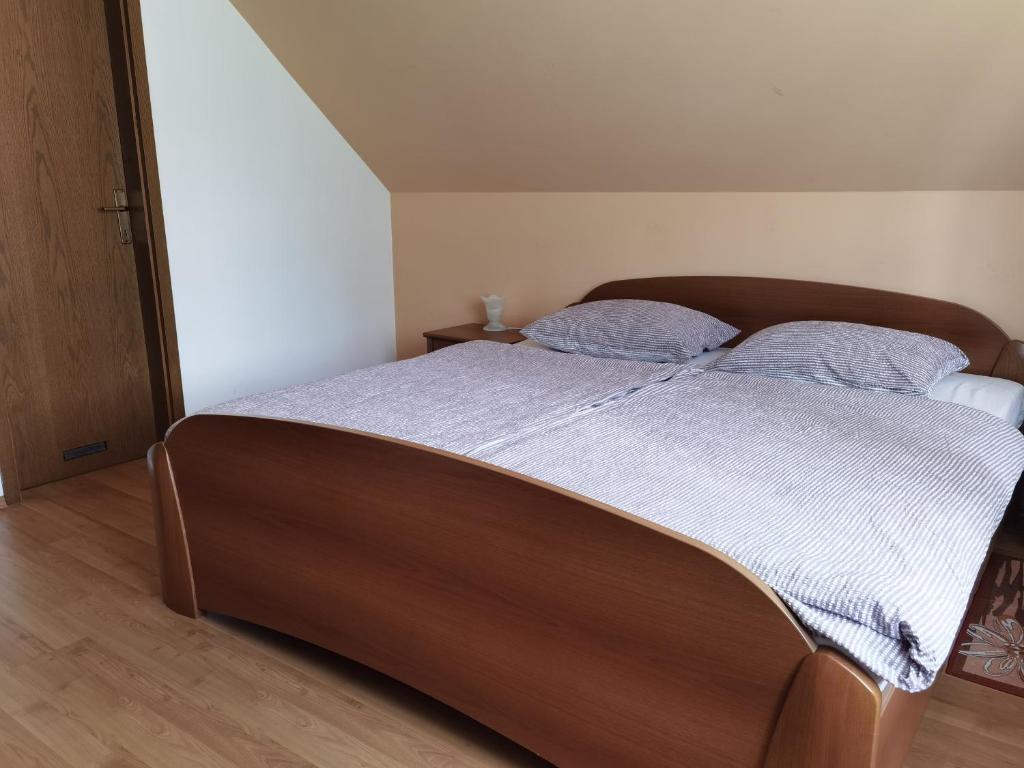 1 dormitorio con 1 cama grande y 2 almohadas azules en Gostišče Hedvika, en Kal-Koritnica