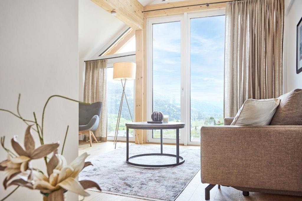 a living room with a couch and a table at Die Tauplitz Lodges - Bergblick B7-2 by AA Holiday Homes in Tauplitz