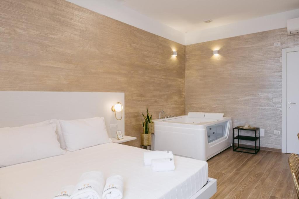 una camera con letto bianco e lavandino di Porta D'Oro Charming House ad Alghero