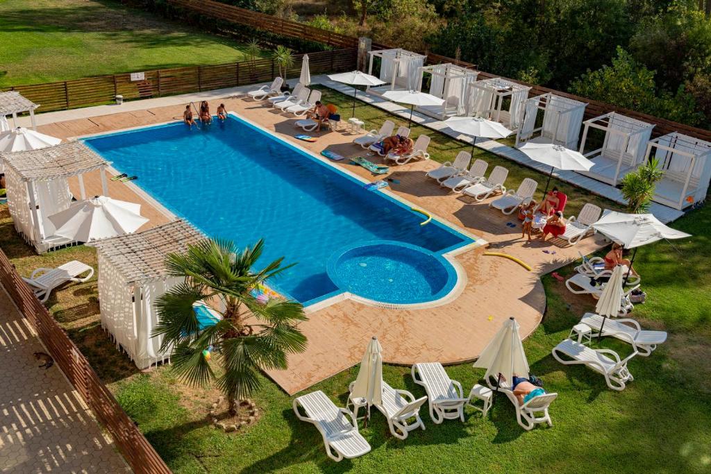 una vista aérea de una piscina con sillas y sombrillas en Menada Rocamar Apartments, en Tsarevo