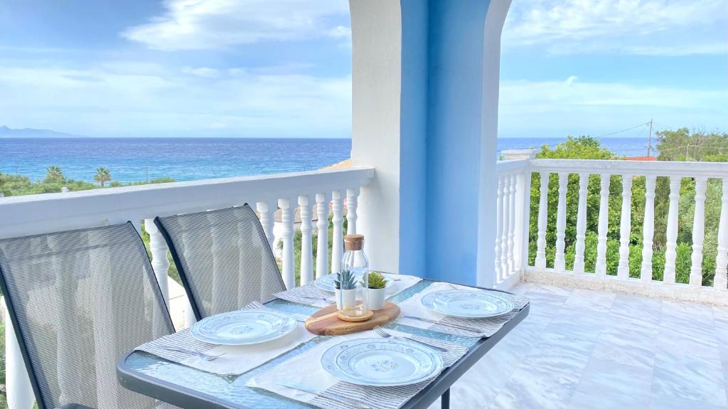 a table on a balcony with a view of the ocean at Andrikas Villa at Xenios Avlais in Zakynthos Town