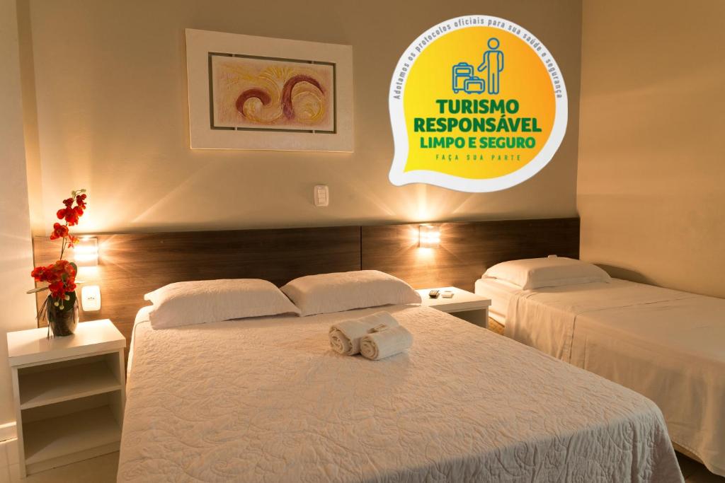 um quarto de hotel com duas camas e uma placa na parede em Hotel Locatelli em Lajeado
