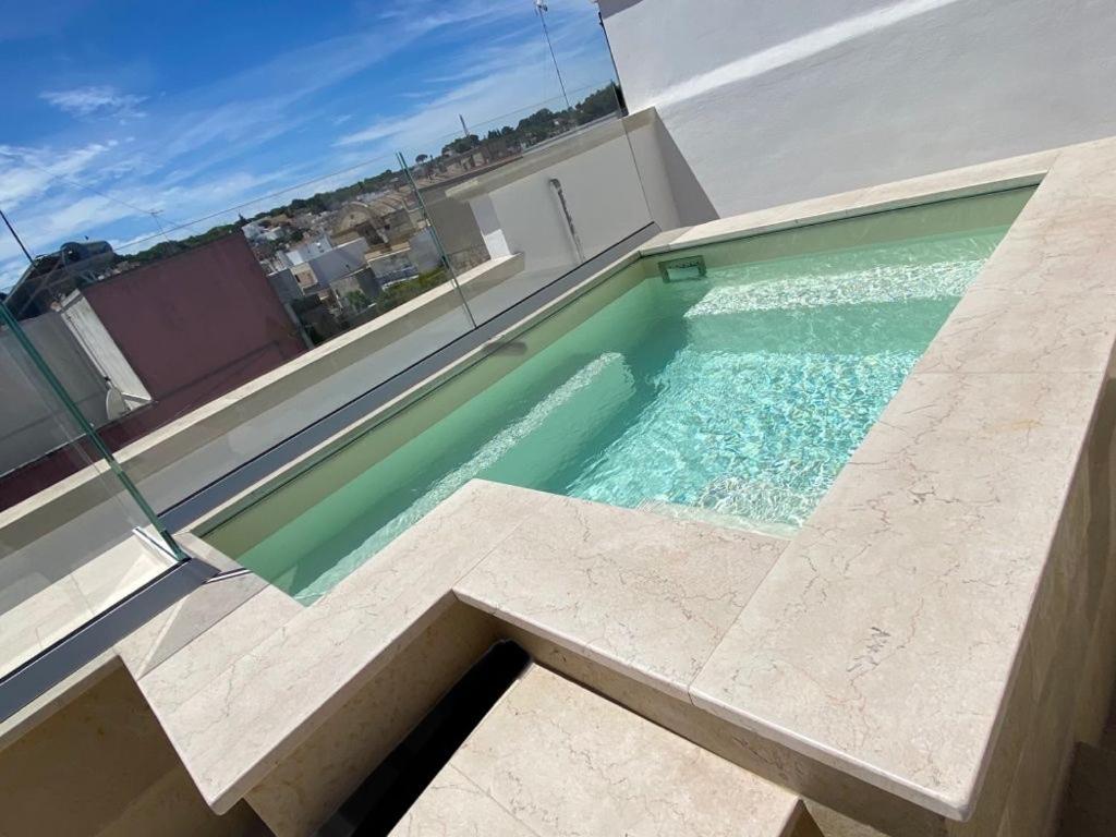 een zwembad aan de zijkant van een huis bij La Bianca Terrazza in Alessano