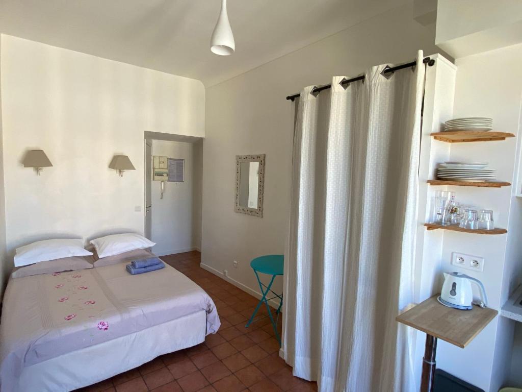 - une petite chambre avec un lit et une fenêtre dans l'établissement Studios Floreal, à Nice