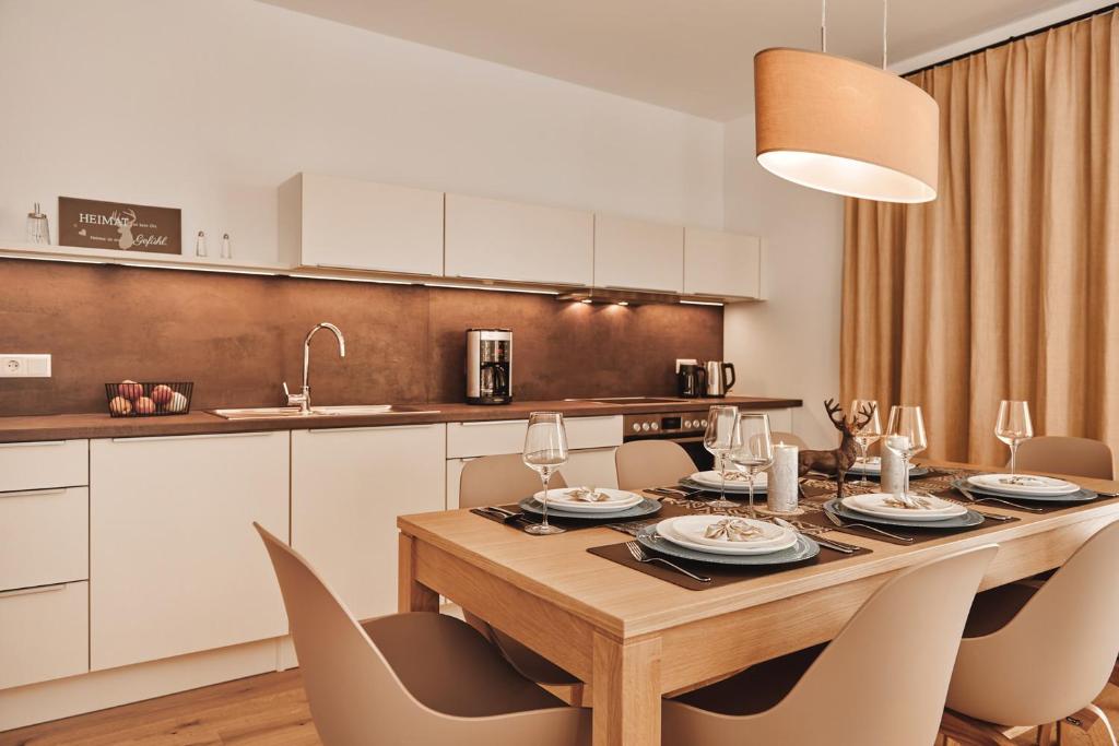 a dining room table with chairs and a kitchen at die Tauplitz Lodges - Wasserfall Lodge C1 by AA Holiday Homes in Tauplitz