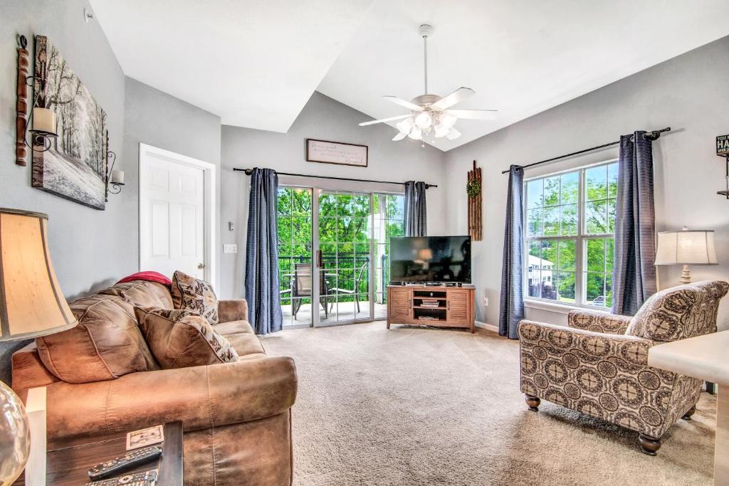 uma sala de estar com um sofá e uma TV em Hollowed Branch Hideaway Condo em Branson
