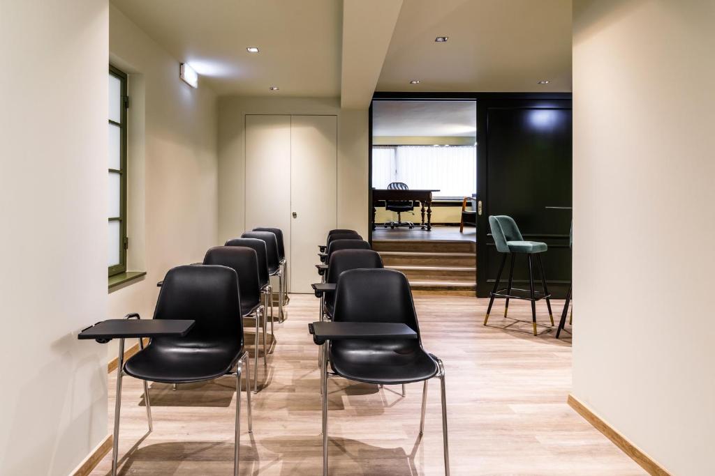 a row of black chairs in a waiting room at Abc Hotel in Thessaloniki