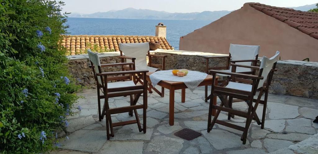a table and chairs on a patio with a view of the ocean at Athina Guesthouse in Monemvasia