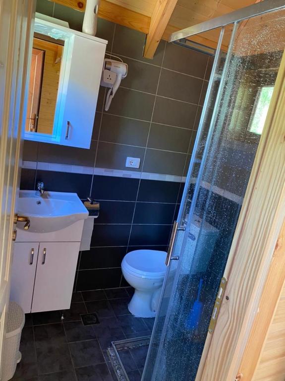 een badkamer met toilet, wastafel en douche bij 5 Stinet in Koman