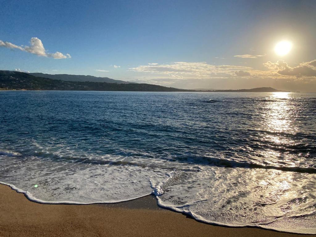 a view of a beach with the sun reflecting on the water at Holiday Inn Express Ajaccio by IHG in Ajaccio